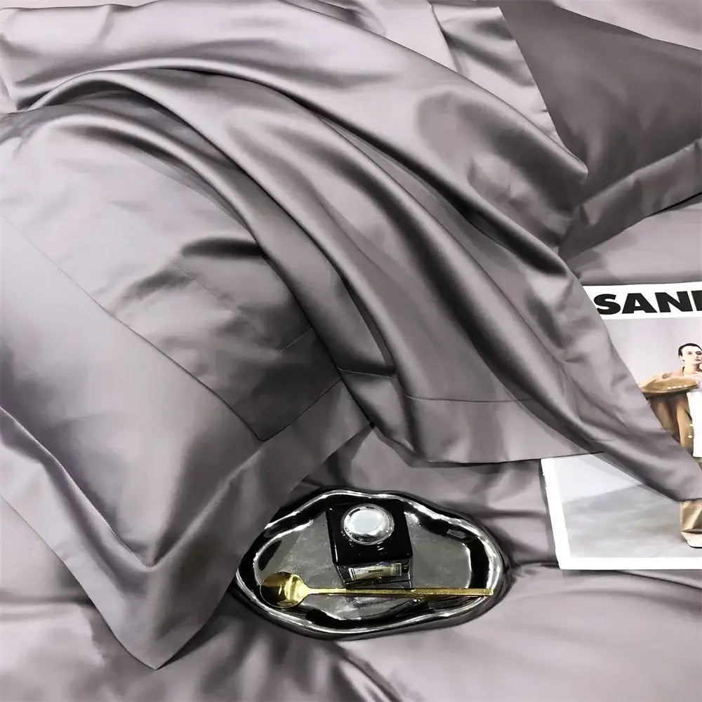 A sleek metallic tray with a black inkwell and gold spoon complements the luxury gray egyptian cotton bedding set