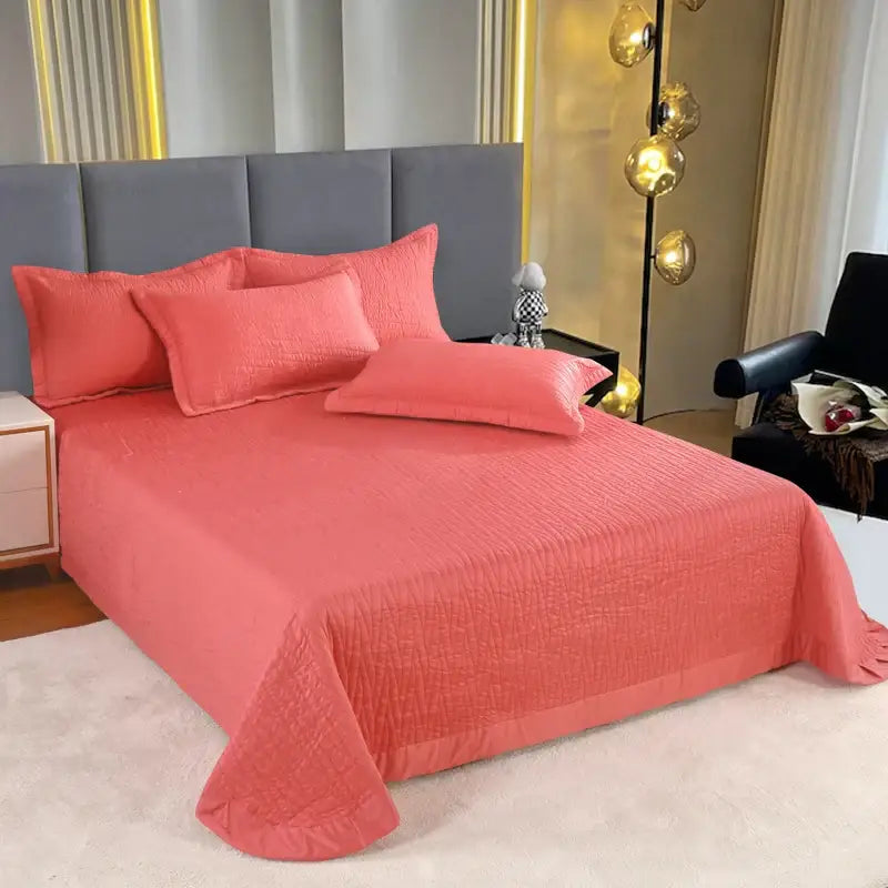 Luxury gray textured egyptian cotton quilt set featuring a coral-colored quilted bedspread with woven pattern and ruffled edges