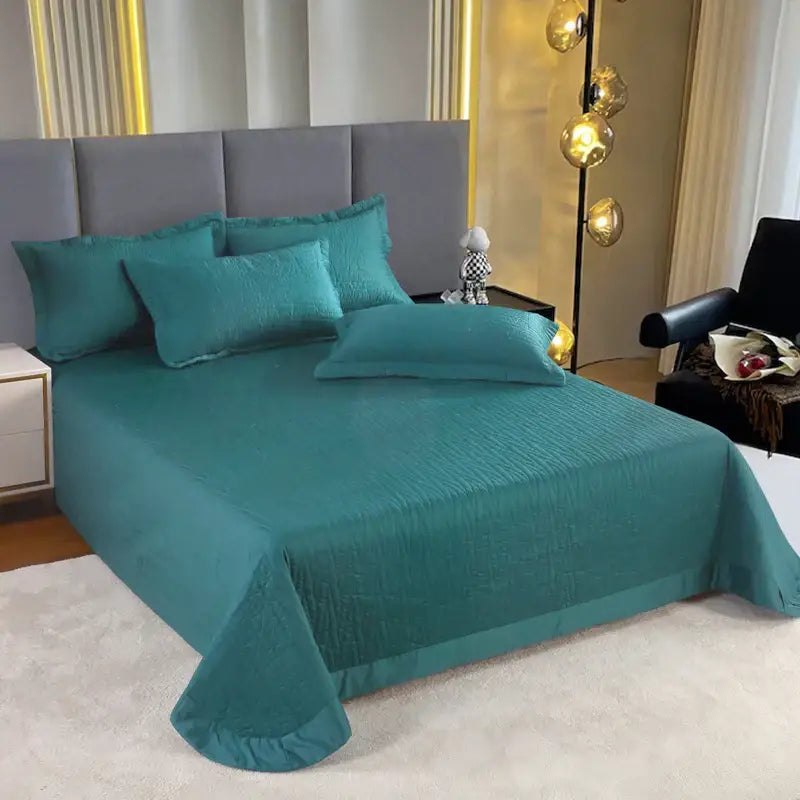 Teal-colored cotton quilt set with textured quilted fabric and ruffled edges for luxury bedroom bedding