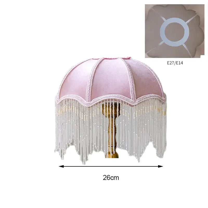 A delicate pink velvet lampshade with scalloped edges and white lace trim complementing luxury green velvet tasseling decorbites crystal fringe