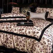 Luxury leopard print satin bedding set featuring a cream duvet cover with bold brown decorbites leopard print and black trim