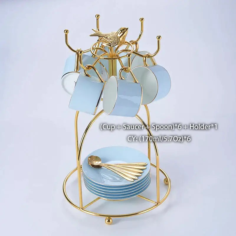 Gold metal cup rack with bird finial holding six light blue decorbites bone china coffee set mugs and saucers with gold spoons