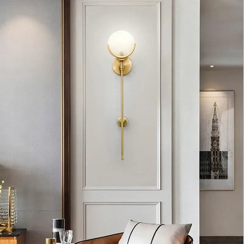 Luxury marble and copper wall lamp featuring a gold-toned copper wall sconce with frosted glass globe for bedroom use