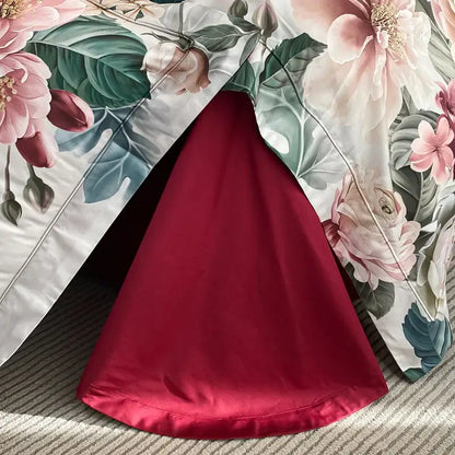 A vibrant red satin skirt with a flowing cone silhouette displayed alongside luxury pink and cream egyptian cotton flower bedding set