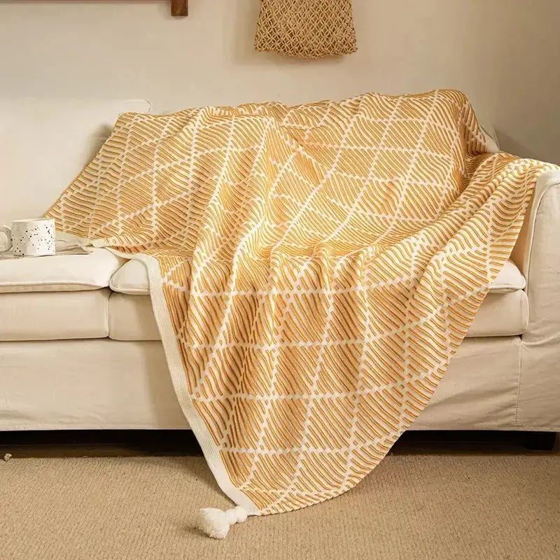 Luxury plaid knit sofa blanket in mustard yellow with cream geometric weave and white tassel by decorbites knit sofa