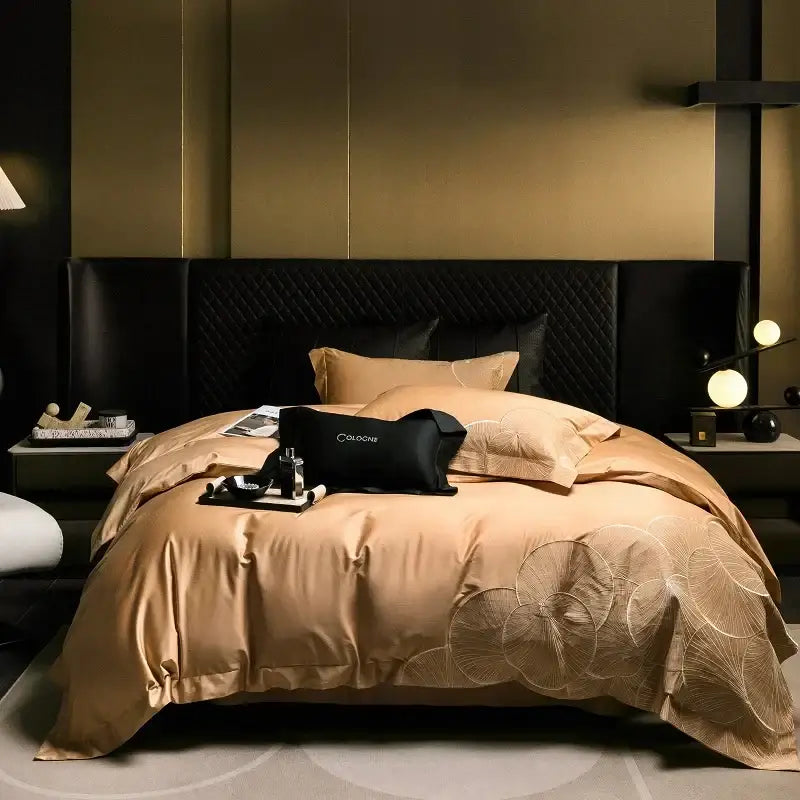 The elegant gold satin cotton bedding set with embroidered leaf pattern and black quilted pillows for luxury bedrooms