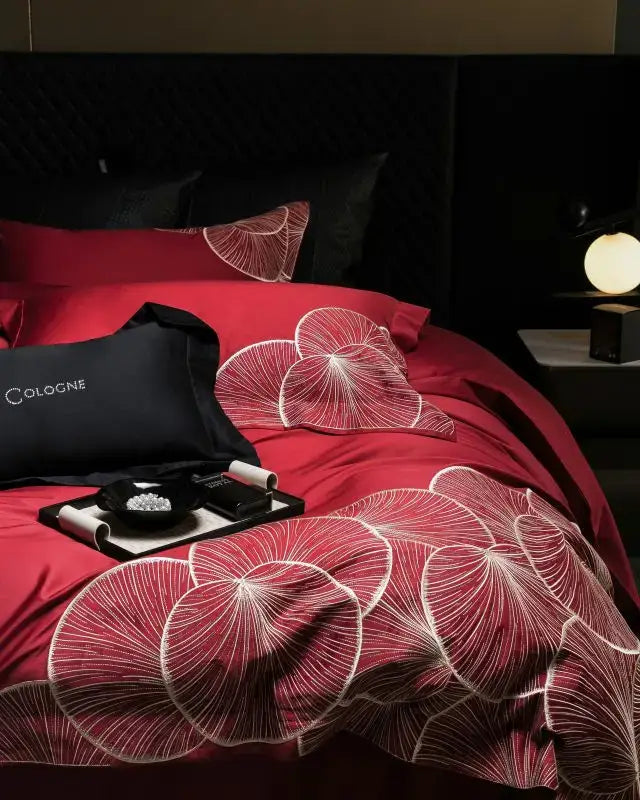 Luxury red satin duvet cover with intricate white lotus embroidery in a cotton bedding set for bedroom use