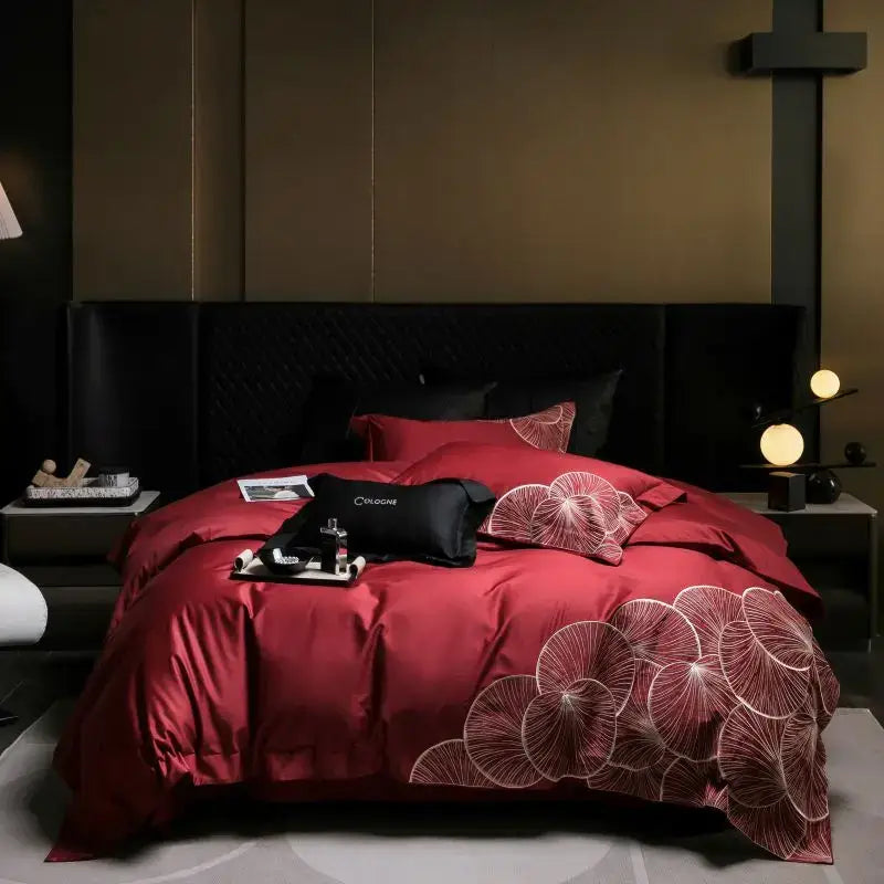 Red satin duvet cover with white embroidered lotus patterns in a luxury cotton bedding set for bedroom use