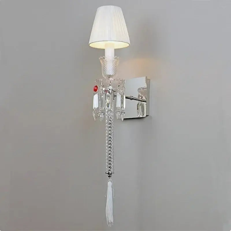 Elegant silver-toned decorbites crystal wall lamp with clear faceted glass and white pleated shades for bedroom decor