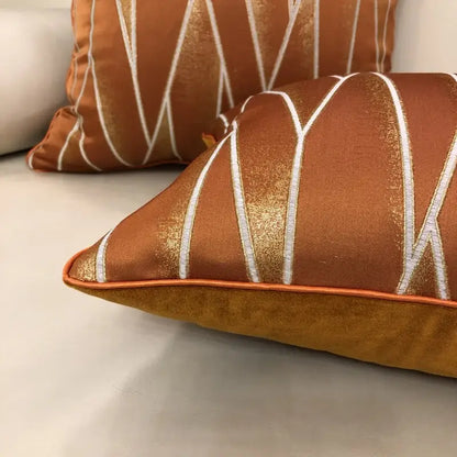 Luxury cushion cover with copper tone and white gold geometric embroidery made from silver quilted jacquard fabric