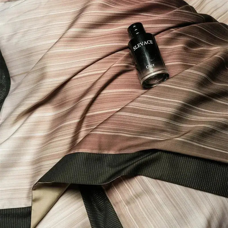 A sleek black dior sleavece perfume bottle on a taupe and beige striped lyocell cotton bedding set by decorbites light luxury