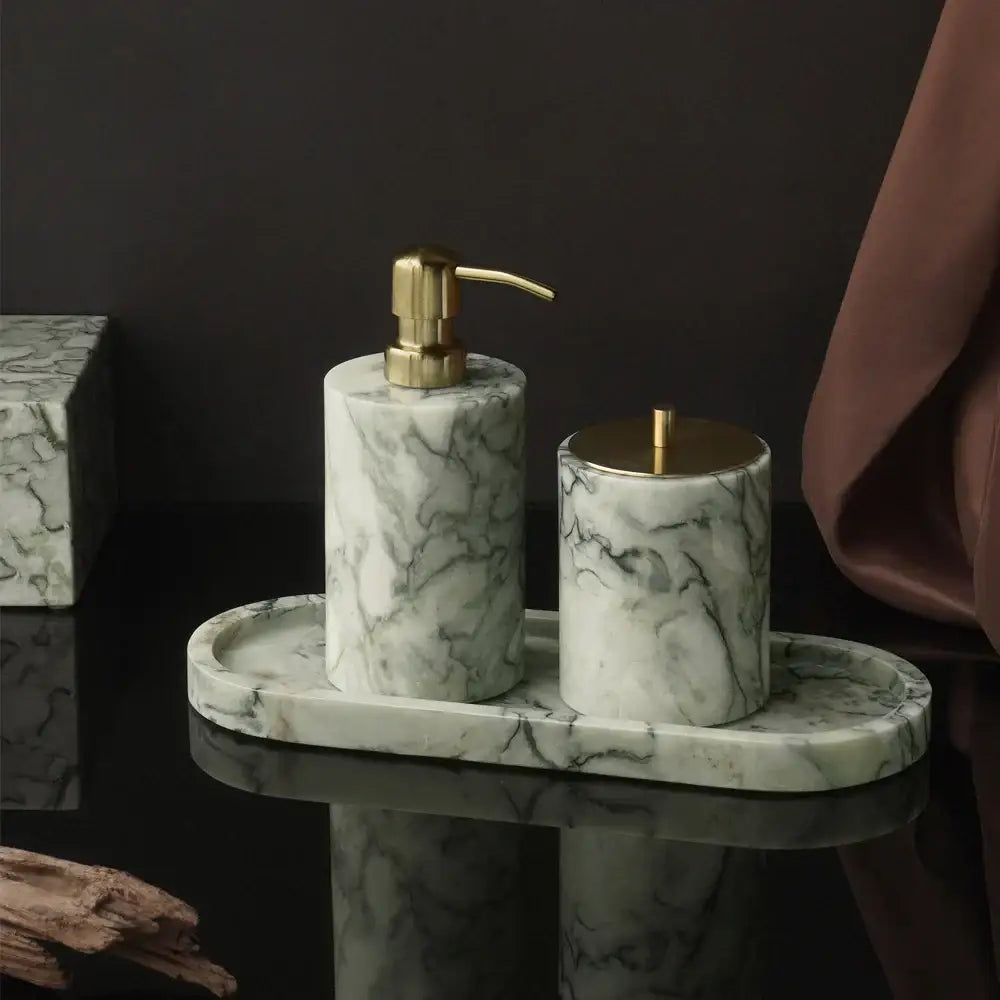 Luxury white and gold marble bathroom set with emerald marble accents featuring gold-tone pump and lid details