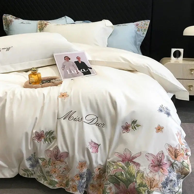 Luxury white miss dior bedspread with delicate cotton flowers embroidery in soft pink, peach and blue hues on egyptian cotton