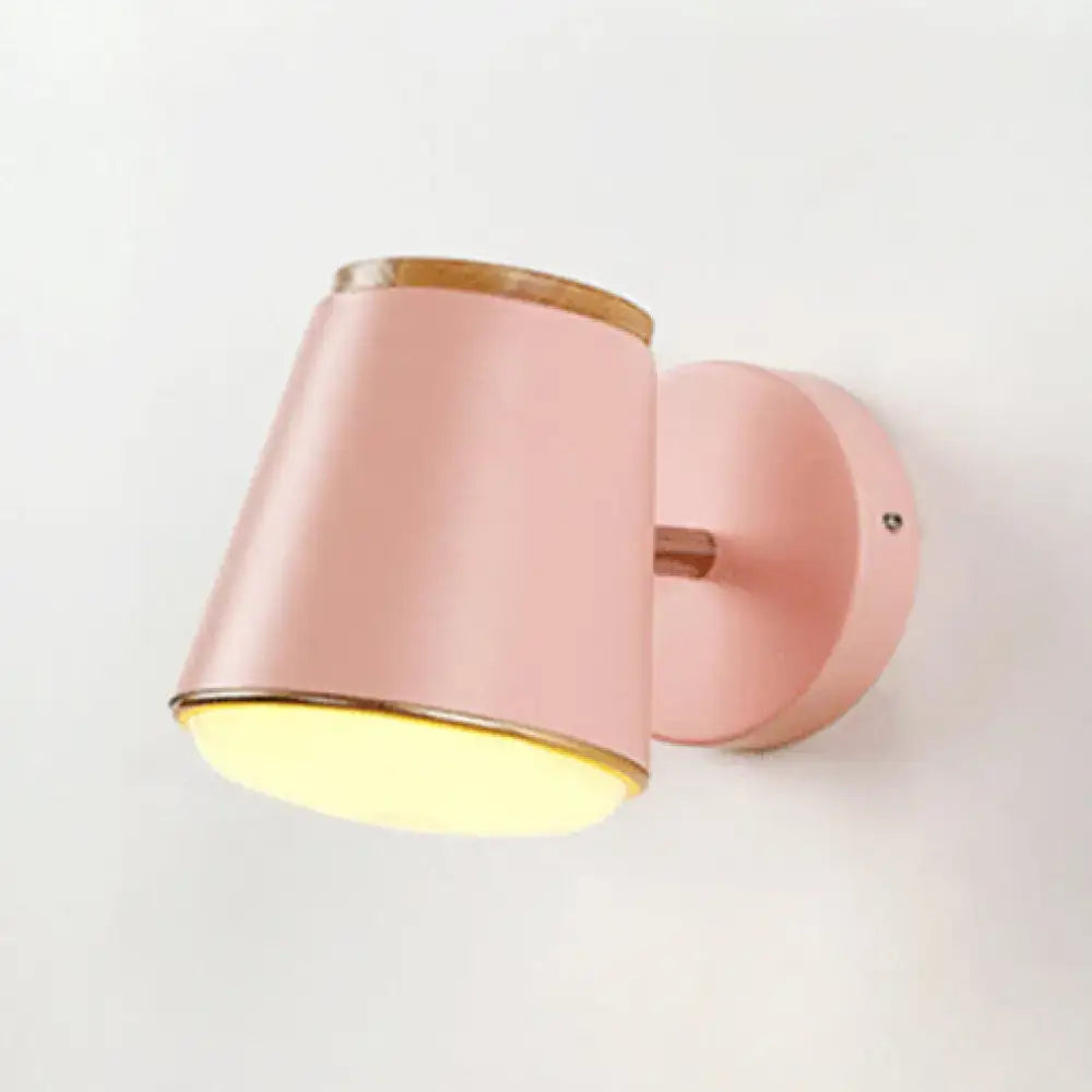 Macaron pink and gold fabric wall lamp featuring a cylindrical wall light with wooden accents for bedroom decor