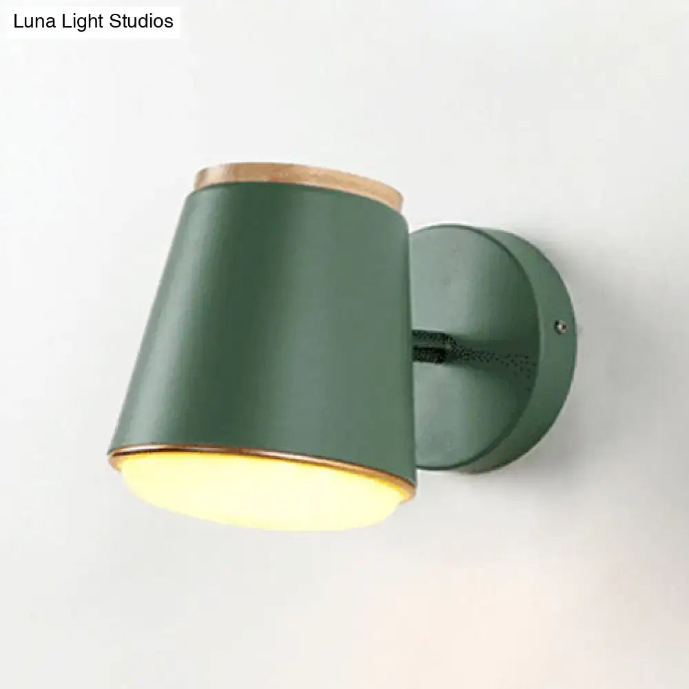 A sleek matte green wall lamp fixture with natural wood trim and cylindrical shade for bedroom wall light use