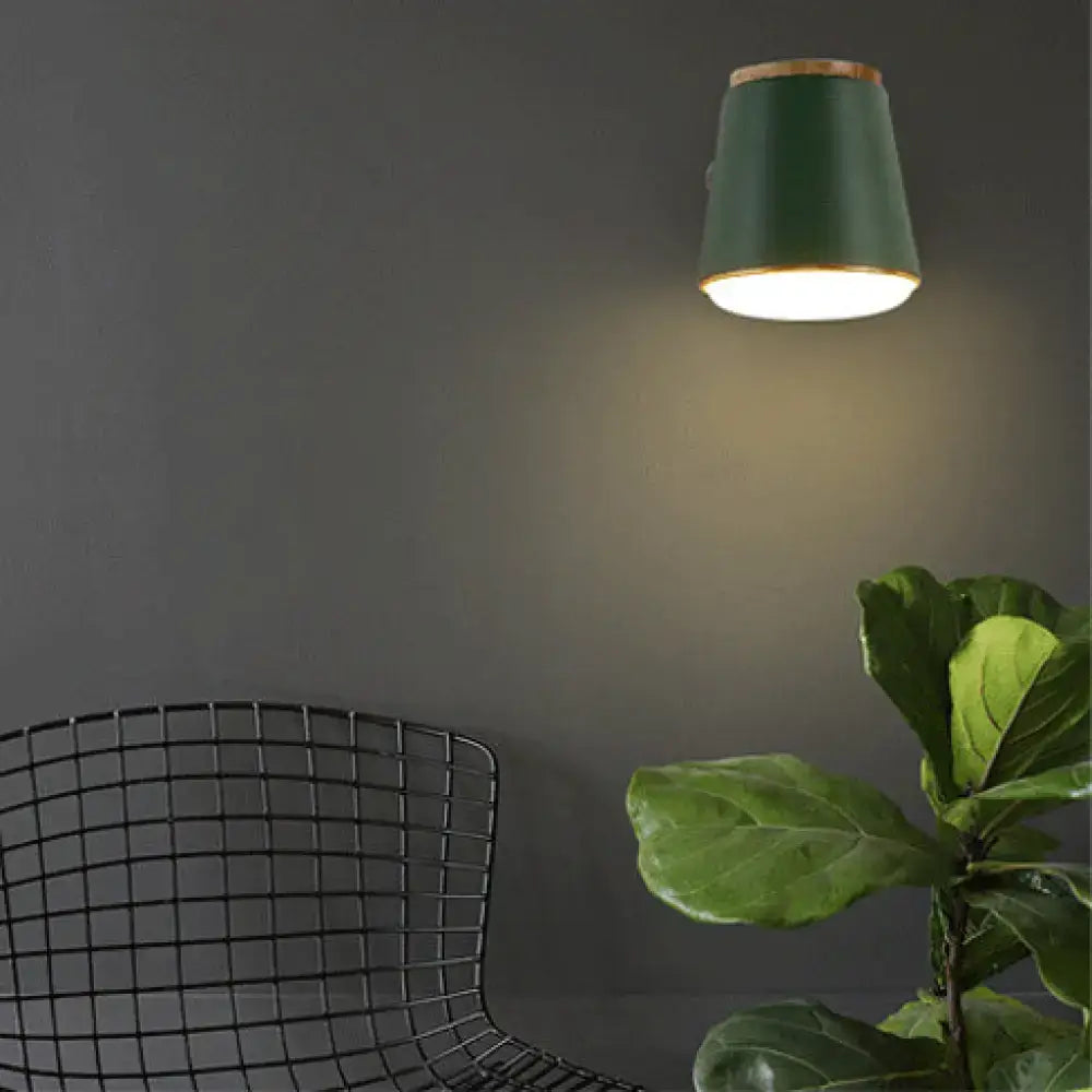 A sleek dark green ceramic wall lamp fixture with natural wood accents suitable as a bedroom wall light