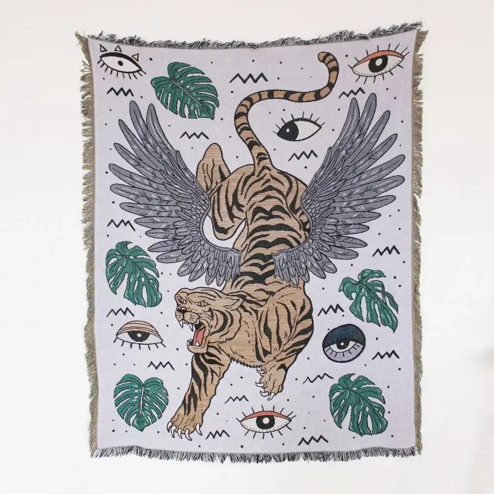 A woven mandala black geo tassel picnic mat and sofa cover featuring a winged tiger and green monstera leaves design