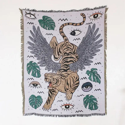 A woven mandala black geo tassel picnic mat and sofa cover featuring a winged tiger and green monstera leaves design