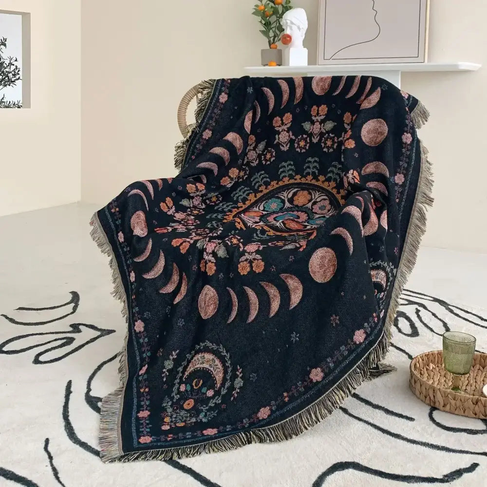Black throw blanket with intricate moon floral patterns and fringe used as mandala geo tassel picnic mat or sofa cover