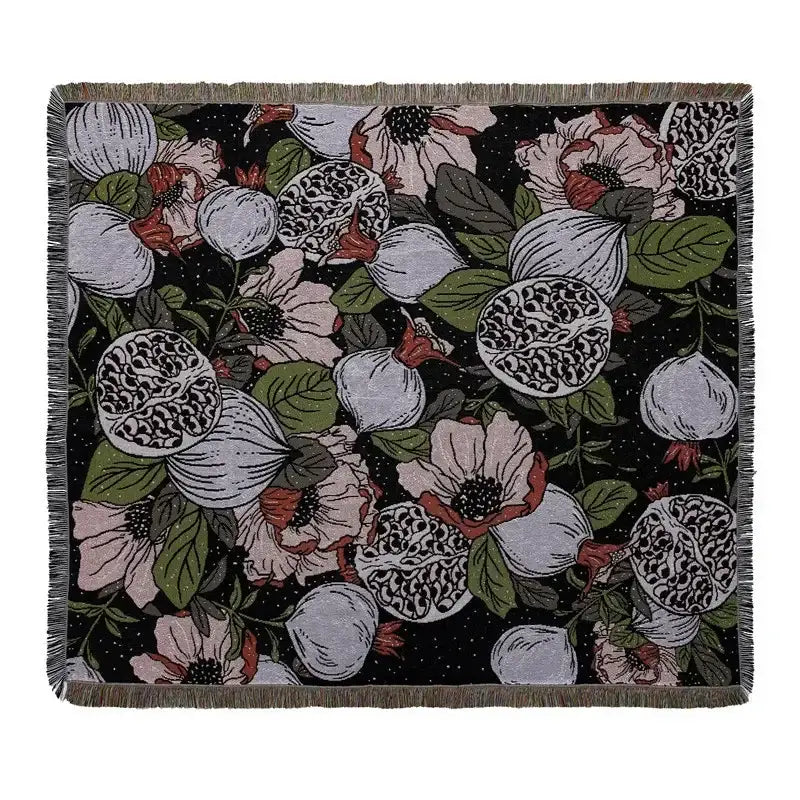 Black throw blanket with floral pomegranate pattern and fringed edges used as geo tassel picnic mat and sofa cover