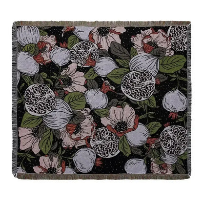 Black throw blanket with floral pomegranate pattern and fringed edges used as geo tassel picnic mat and sofa cover
