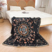 Black throw blanket with intricate mandala design and fringed edges used as geo tassel picnic mat and sofa cover