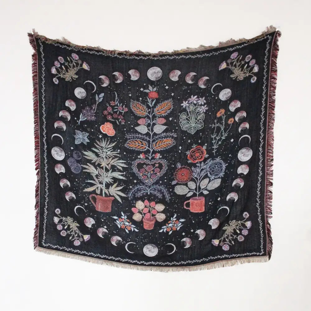 Black woven throw blanket with fringed edges and botanical lunar phase design as geo tassel picnic mat and sofa cover