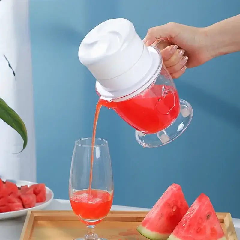 Clear glass pitcher with white plastic lid and handle filled with red watermelon juice for decorbites fruit juice extractor