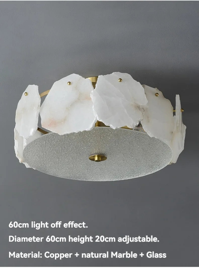 A modern marble led chandelier round pendant light with irregular white marble slices on a brass frame and silver glass base