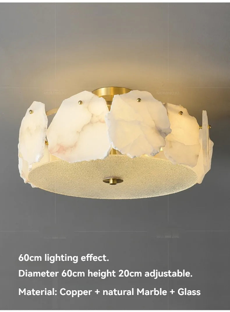A modern marble led chandelier round pendant light with white marble slices around a brass base and glass diffuser