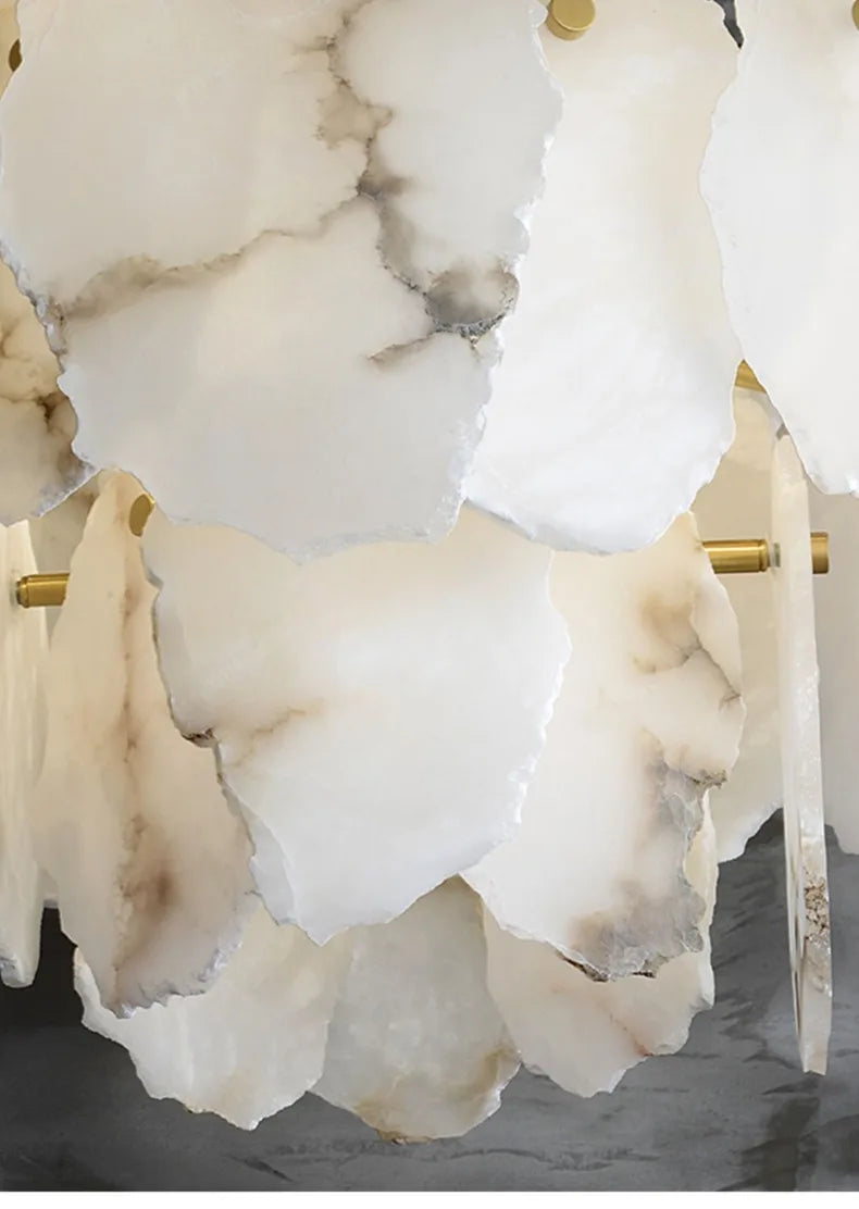A marble led chandelier round pendant light with layered white and gray marble-like petals and gold-toned rods