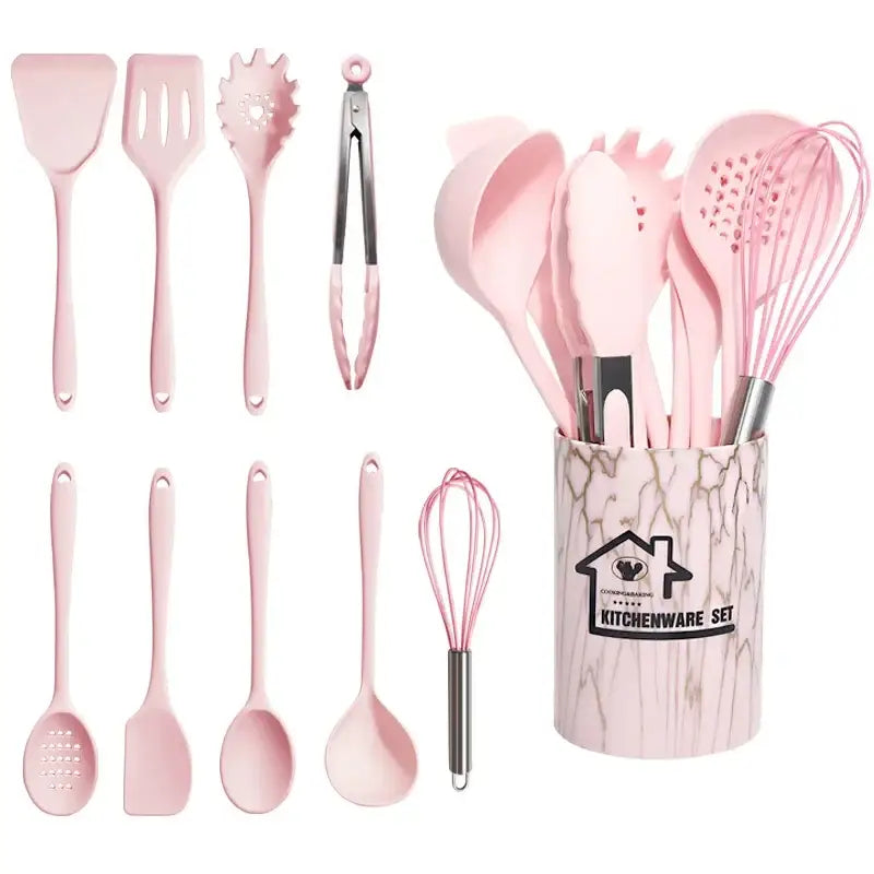Pink silicone cooking tool set with stainless steel accents in a marble-patterned kitchen storage container