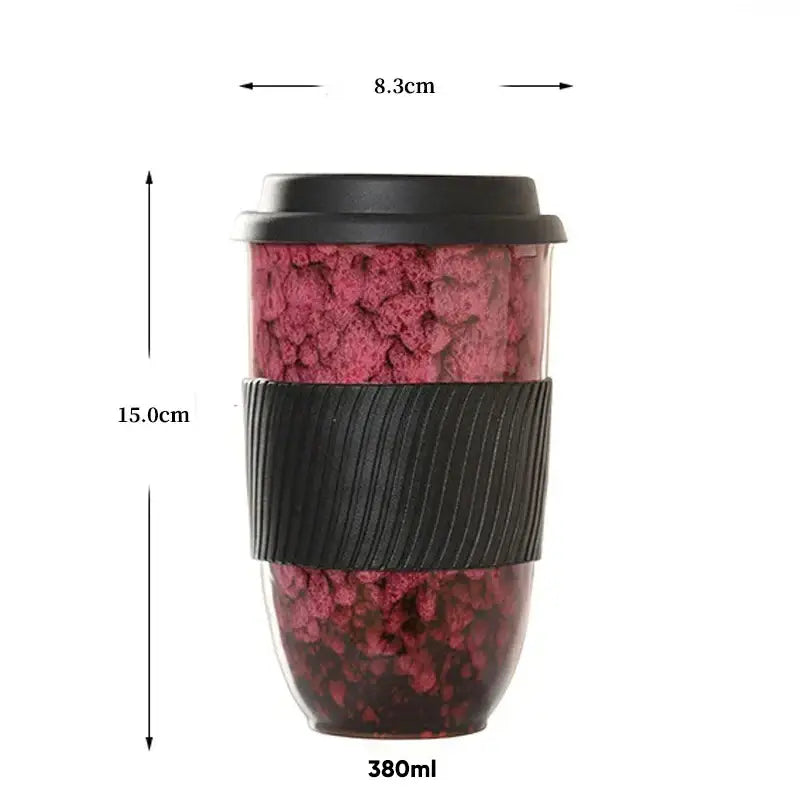 A 380ml decorbites ceramic kiln mug with a pink and black speckled exterior and silicone grip for travel use