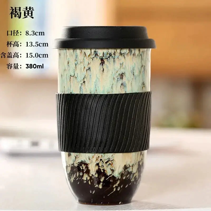Marbled ceramic kiln mug with mottled green and cream glaze featuring a black silicone grip by decorbites ceramic