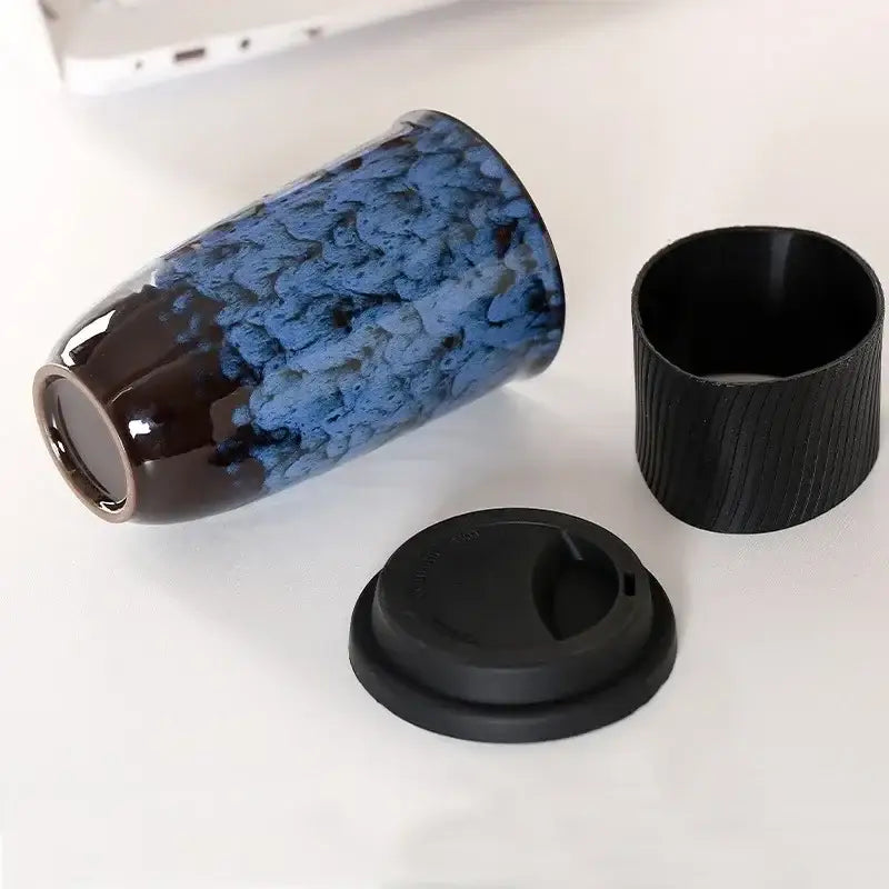Blue and black decorbites ceramic kiln mug with textured crackled glaze and silicone grip for travel use