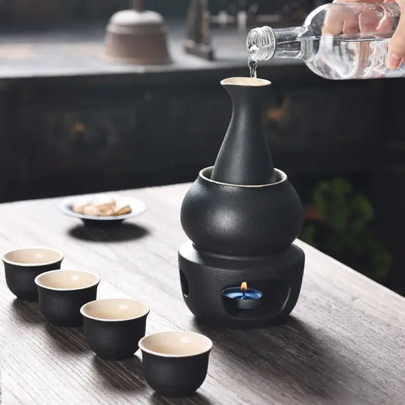 Matte black and light blue decorbites ceramic sake set with glossy finish double-humped decanter on heated warmer base