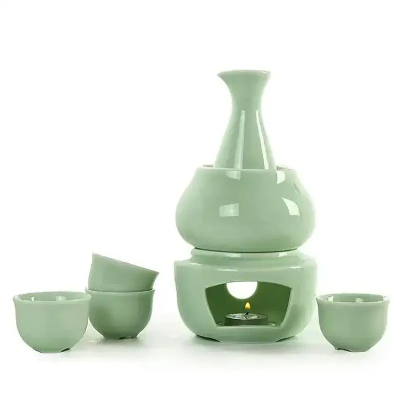 A sleek pale green decorbites ceramic sake set with tiered heater and matching cups in matte black and light blue kit