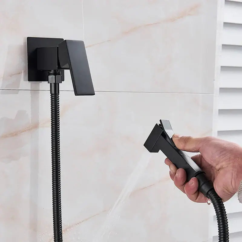 Matte black brass bidet faucet with handheld spray featuring a wall-mounted ergonomic bidet faucet by decorbites
