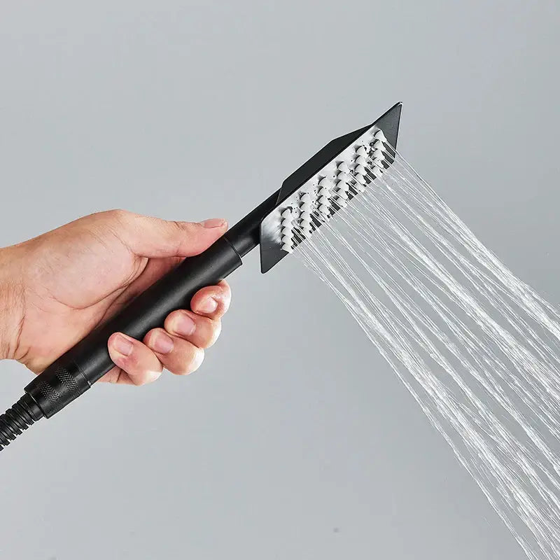 Matte black handheld shower head with stainless steel finish and multiple nozzles emitting water streams in bathroom