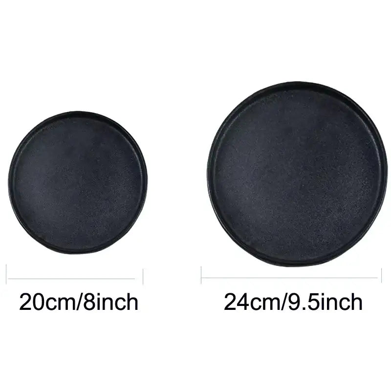 Two black ceramic dinner plates with a matte finish and raised rims from decorbites black ceramic collection