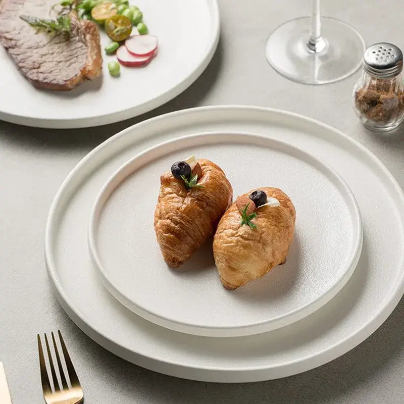 White ceramic dinner plates with subtle texture stacked elegantly alongside decorbites black ceramic dinner plate tray