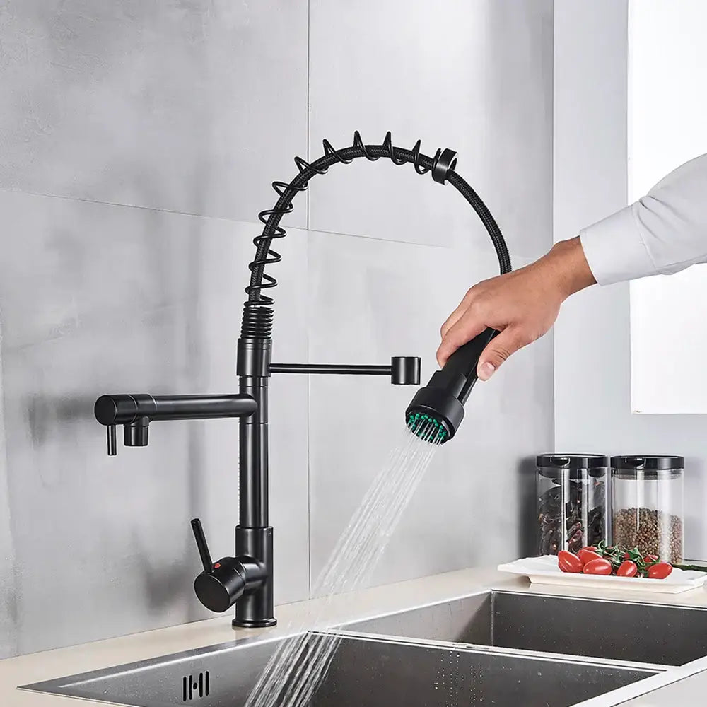Matte black decorbites brass kitchen faucet with swivel spout, coiled flexible hose, and green-tipped spray head
