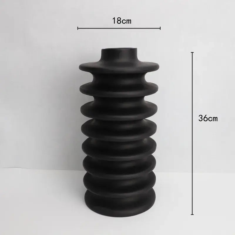 Matte black ceramic vase with stacked ribbed design featuring geometric circle spiral pattern for living room decor