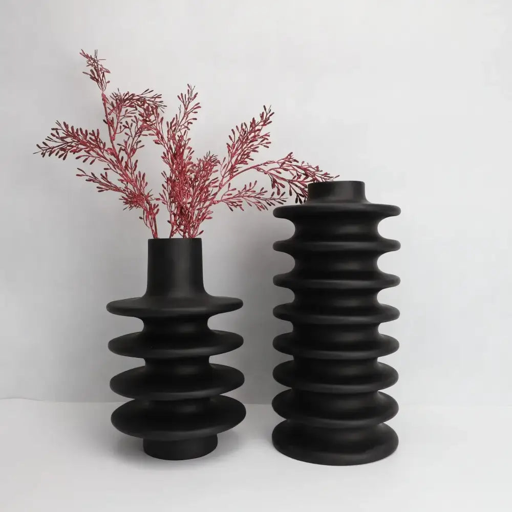 Two matte black ceramic vases with a geometric circle spiral design and narrow neck for living room decor