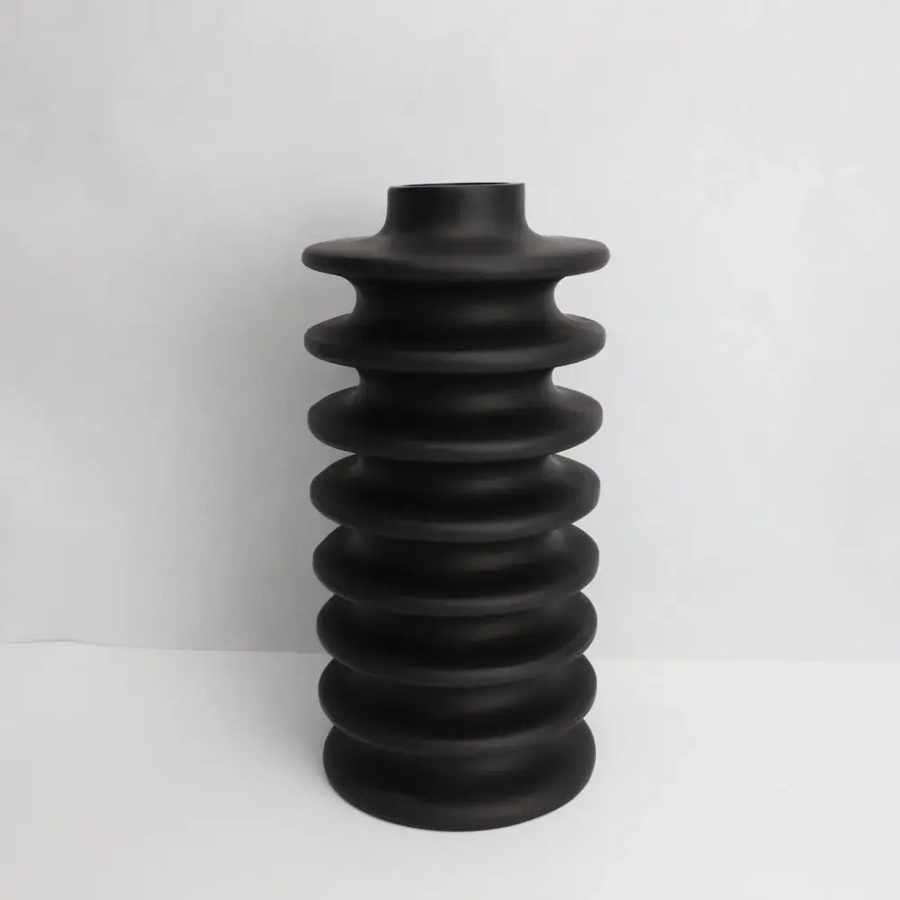 Matte black ceramic vase with geometric circle spiral ribbed rings creating a textured segmented design for living room decor