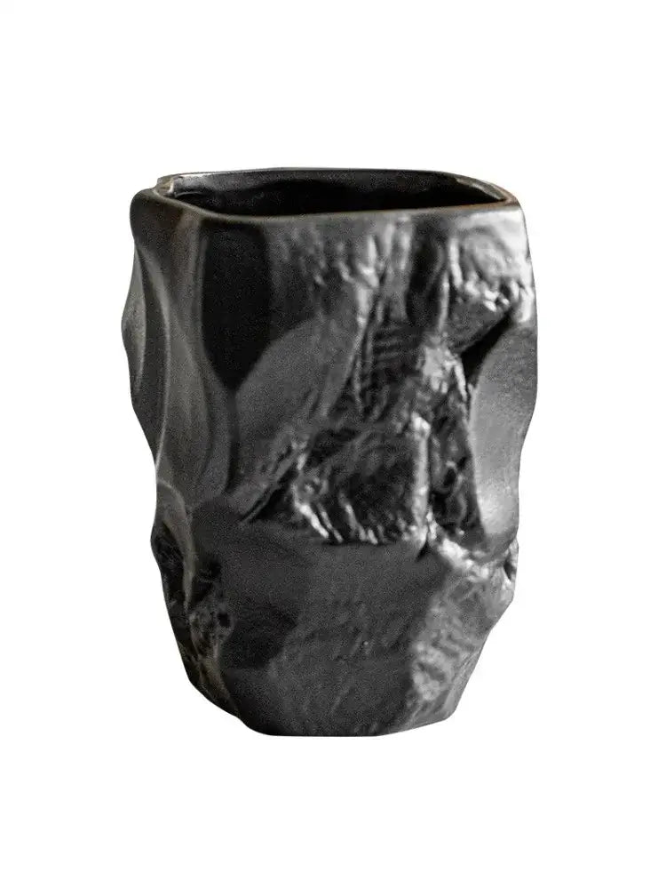 Matte black irregular shaped mouthwash cup with rugged cracked stone texture made from silicone mold by decorbites