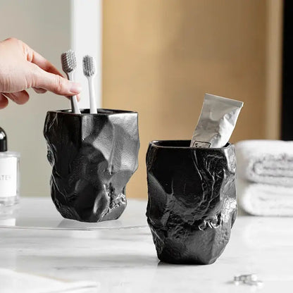 Matte black ceramic mouthwash cup with rugged faceted texture made from silicone mold decorbites irregular shaped design