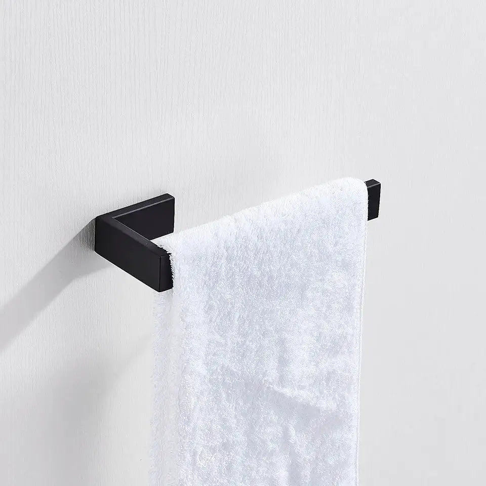 Matte black metal bathroom hardware set featuring a towel rack with a matte finish holding a white textured towel