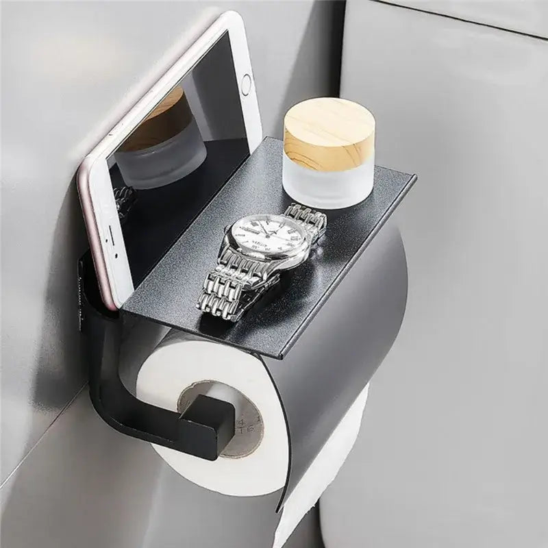 Matte black metal toilet paper holder with attached silver shelf for bathroom storage and paper holder functionality
