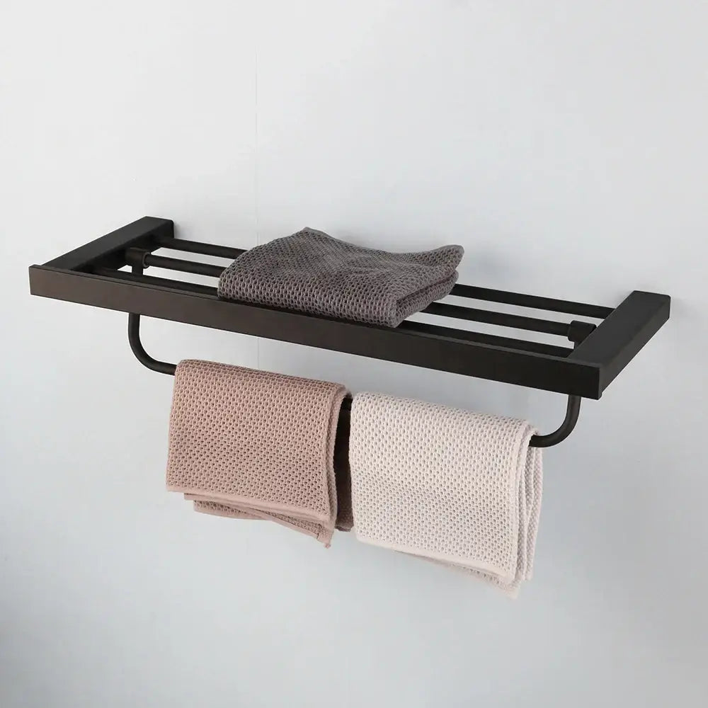 Matte black stainless steel bathroom hardware set featuring a sleek towel rack holding folded gray and beige towels